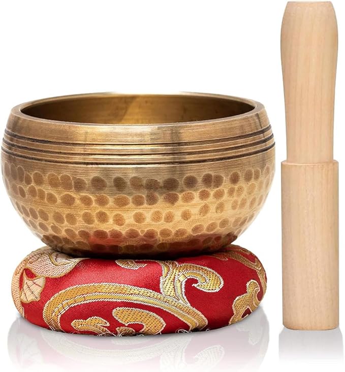 Metal singing bowl with red cushion and wooden mallet