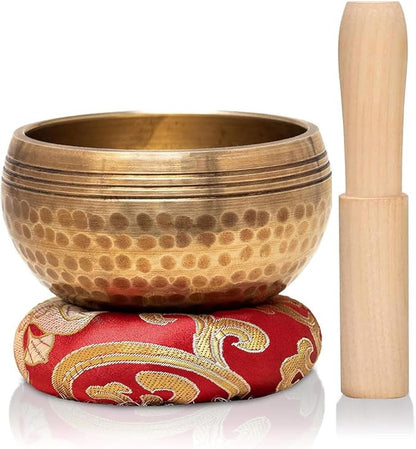 Metal singing bowl with red cushion and wooden mallet