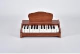 Small brown children's keyboard piano on white background